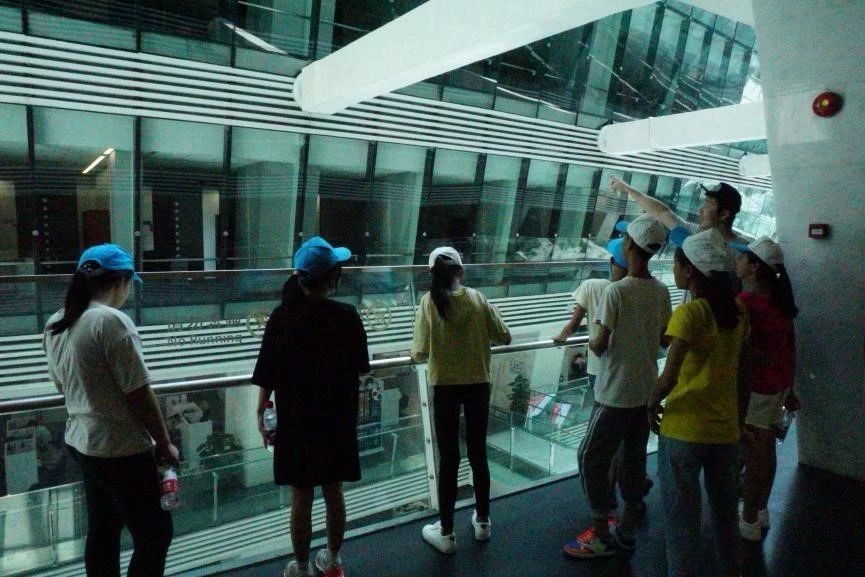 幕天工作人员正向孩子们介绍广州图书馆，告诉他们在什么地方能够找到什么样的书。
